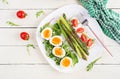 Green asparagus with boiled eggs and sandwich cream cheese on a white plate. Royalty Free Stock Photo