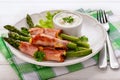 Green asparagus grilled with ham and cheese, served with garlic sauce. Royalty Free Stock Photo