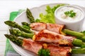 Green asparagus grilled with ham and cheese, served with garlic sauce. Royalty Free Stock Photo