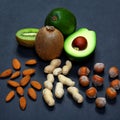 Green assortment vegetables and fruits, avocados, kiwi and almonds, hazelnuts, peanuts, nuts on a shale board, the concept of heal