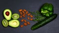 Green assortment vegetables and fruits, avocados, kiwi, pepper and cucumber, almonds, nuts on a shale board, the concept of health Royalty Free Stock Photo