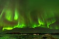 Green auroral light streaking through the sky in the middle of the night