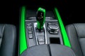 Green Automatic gear stick transmission of a modern car, multimedia and navigation control buttons. Car interior details. Transm