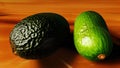 Green avocados close-up on a wooden brown table. Still life with avocado. Generated AI.