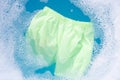 Green baby shorts soak in baby laundry detergent water dissolution, washing cloth, Laundry concept