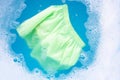 Green baby shorts soak in baby laundry detergent water dissolution, washing cloth, Laundry concept