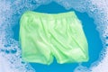 Green baby shorts soak in baby laundry detergent water dissolution, washing cloth, Laundry concept