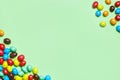 Green background for a children`s holiday poster. Flatley. Top view round multicolored candies