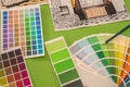 on a green background laid out colored palettes, samples and drawings of the house with a pencil Royalty Free Stock Photo