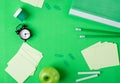 Green background with stationery supplies, alarm clock and apple Royalty Free Stock Photo