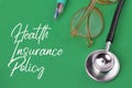 Green background written with text HEALTH INSURANCE POLICY Royalty Free Stock Photo