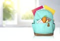 Green backpack with school supplies on white table,empty copy space backdrop