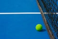 Green ball falling on floor nearly white lines of outdoor blue tennis hard court in public park. Royalty Free Stock Photo