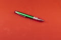 Green ballpoint pen on red background