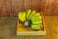 Green banana in an wood box, on sack sisal background Royalty Free Stock Photo