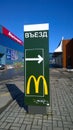 Green Banner of McDonald`s fast food cafe with Exit Sign and directional arrow for car buyers. City street. McCafe logo. Delivery