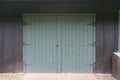 Green Barn Doors on Black Wall Royalty Free Stock Photo