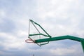 Green basketball stand with glass backboard in cloudy sky