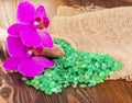 Green bath salt in spoon on wooden surface and Orchid. Royalty Free Stock Photo