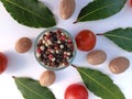 Green bay leaves, cherry tomatoes, nutmeg, pepper. White background.