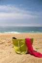 Green beach bag on the seacoast and pink shawl Royalty Free Stock Photo