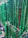 Green beads hanging on the wall. Beads of different shapes and types. Made of natural stone, turquoise. Royalty Free Stock Photo