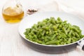 Green beans on frying pan on wooden background Royalty Free Stock Photo