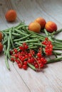 Green beans, green vegetables, beans scattered on a wooden background, redcurrant and fresh apricots, fruits and vegetables Royalty Free Stock Photo