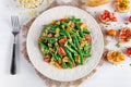 Green beans salad with Red, Yellow Tomatoes, bruschettas and flaked almond on white plate Royalty Free Stock Photo