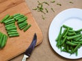 Green beans on a white plate on a table with a knife Royalty Free Stock Photo