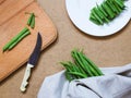 Green beans on a white plate on a table with a napkin and knife Royalty Free Stock Photo