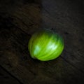 Green beef tomato on a dark wooden table Royalty Free Stock Photo