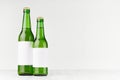 Green beer bottles longneck 500ml and 330ml with blank white label on white wooden board, mock up. Royalty Free Stock Photo