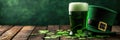 Green beer pint and leprechaun hat over dark green background, decorated with shamrock leaves Royalty Free Stock Photo