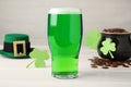 Green beer and St Patrick`s Day decor on white wooden table