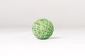 Green and beige knitted ball, pet toy, lying down on emtpy white background in the center of composition.