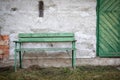 Green Bench and Door in Front of Weathered Wall Royalty Free Stock Photo