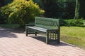 Green bench standing in a park with green plants