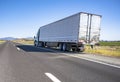 Green big rig semi truck with cargo in refrigerator semi trailer standing out of service on the road shoulder in Washington