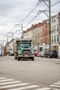 Green big rig tip truck running on the city street Royalty Free Stock Photo