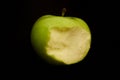 Green bitten apple on dark background Royalty Free Stock Photo