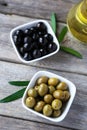 Green and black olives in bowl on grey wooden background. Royalty Free Stock Photo