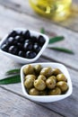 Green and black olives in bowl on grey wooden background. Royalty Free Stock Photo