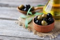 Green and black olives in bowl on grey wooden background. Royalty Free Stock Photo