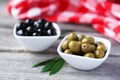 Green and black olives in bowl on grey wooden background. Royalty Free Stock Photo