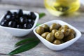 Green and black olives in bowl on a grey wooden background Royalty Free Stock Photo