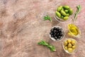 Green and black olives in the bowl, olive oil and fresh rosemary on a dark rustic background. Top view, copy space. Mediterranean Royalty Free Stock Photo