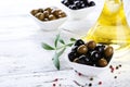 Green and black olives in bowl on a white wooden background Royalty Free Stock Photo