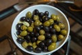 Top view with space for text . Green and black olives in a white ceramic bowl Royalty Free Stock Photo