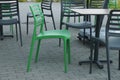 Green and black plastic chairs by the table stand